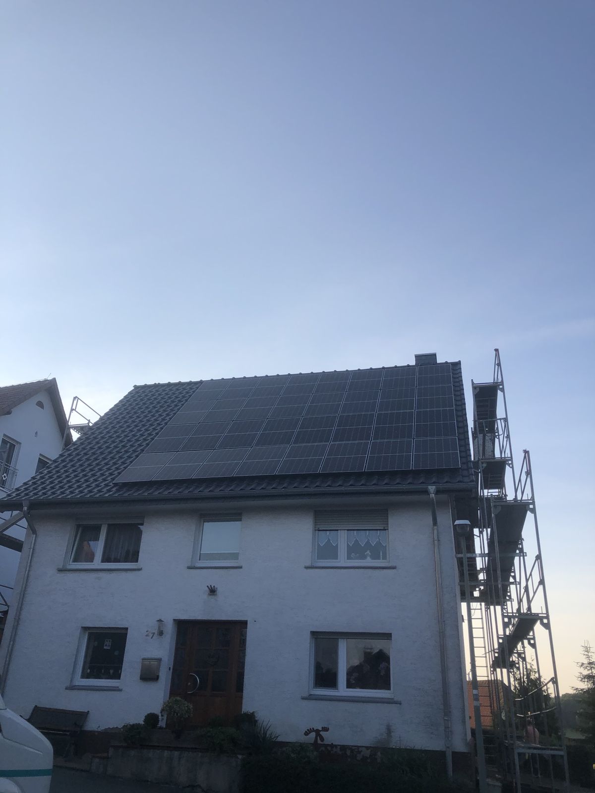 Einfamilienhaus mit neu eingedecktem Dach und Photovoltaik, Gerüst noch am Giebel